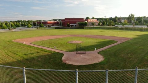 Baseball diamond, athletic fields with American school in Pennsylvania USA during magic hour, sports season cancelled due to Coronavirus COVID