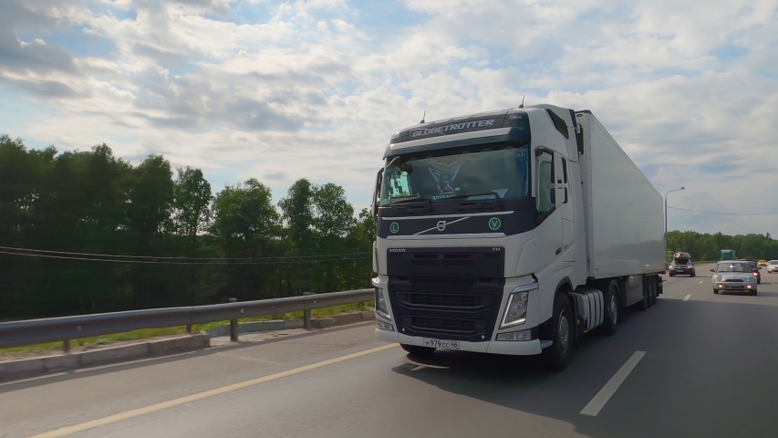 White truck with cargo trailer racing on highway. Domodedovo, Russia - June 27, 2020. | Shutterstock HD Video #1057396672