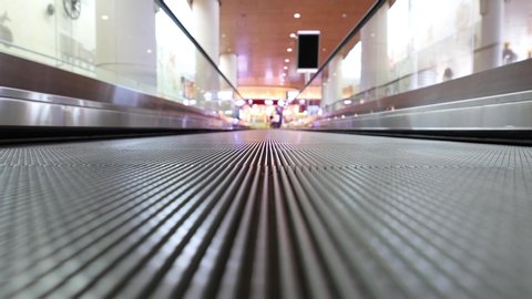 Moving walkway at the airport, also known as an autowalk, moving sidewalk, moving pavement, people-mover, travolator, or travelator, is a slow-moving conveyor mechanism that transports people.