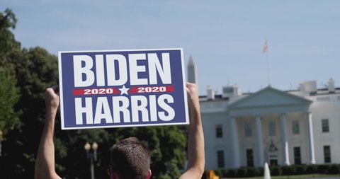 WASHINGTON - Circa August, 2020 - A man holds a Biden/Harris 2020 election protest sign in front of the White House on a sunny summer day.	