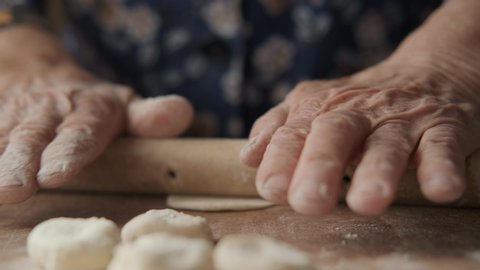 Grandmother Prepares Dumplings, Rolls Dough Uses Rolling Pin. Only the Wrinkled Hands of an Elderly Man In the Frame. Home Food, Culinary Traditions, Traditional Dishes.