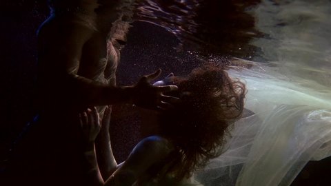 sexual caress of lovers in swimming pool, underwater shot of woman and naked male body