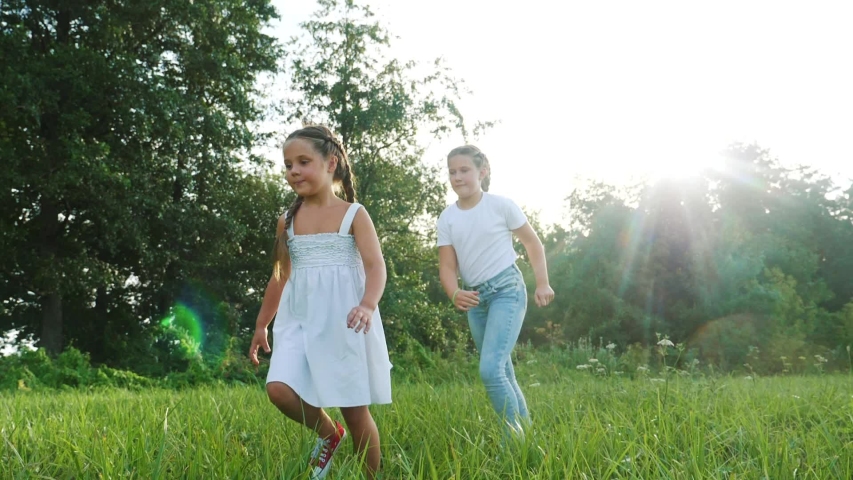 Children kid dream together run in the park at sunset. happy family people in the park concept. two sisters playing catch-up run. baby child fun running in green meadow. happy family dream kid concept | Shutterstock HD Video #1057410964