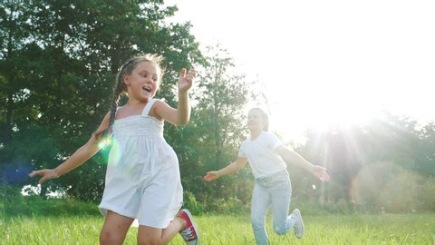 children kid dream together run in the park at sunset. happy family people in the park concept. two sisters playing catch-up run. baby child fun running in green meadow. happy family dream kid concept