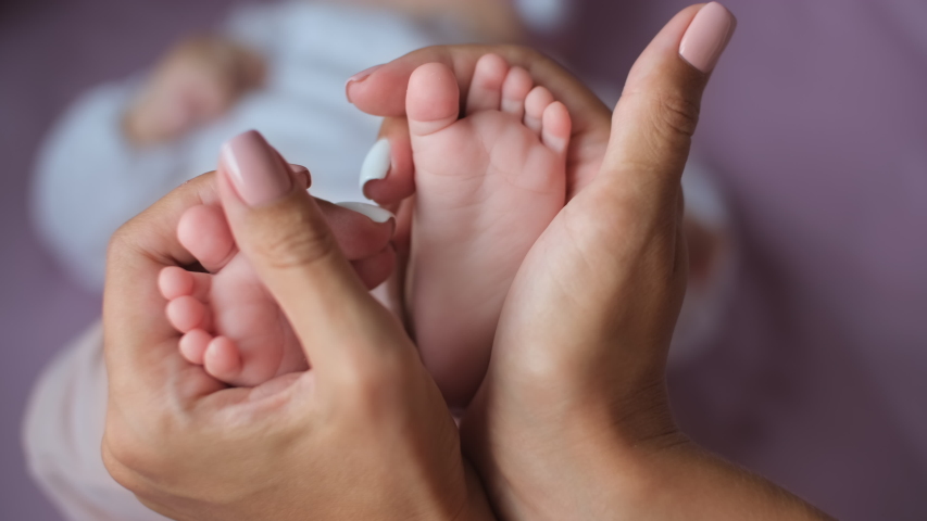 Protect baby, Care and Love, Child Protection . Caring mom holds baby feet in her hands forming a heart shape Royalty-Free Stock Footage #1057411522
