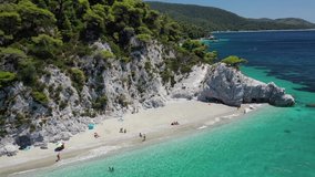 Aerial drone panoramic video of famous turquoise paradise beach of Hovolo covered with pine trees, Skopelos island, Sporades, Greece