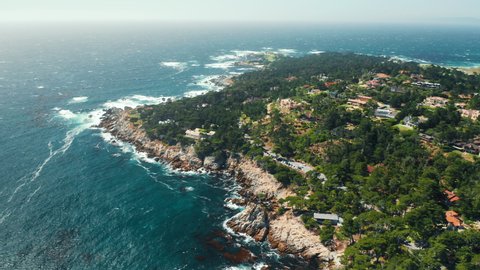 Panoramic aerial view on incredible shore with prestige houses on rocky coastline. Luxury exclusive real estates on the closed lands of 17-mile drive park area. 4K aerial, Monterey, California, USA