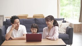 Girl and her parents watching a laptop