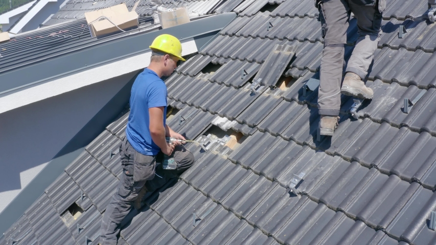 Aerial view of engineer install solar panel by drill on rooftop, Slovenia | Shutterstock HD Video #1057420690