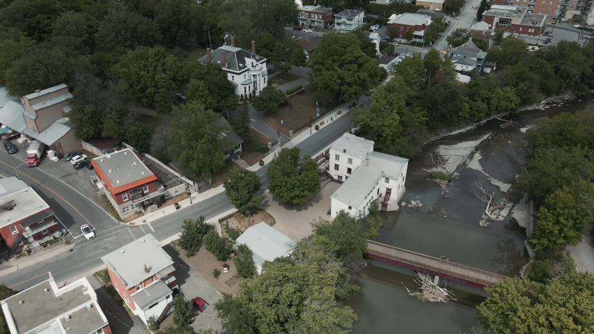 The Historical Legare Mill Across The House of Culture and Heritage Surrounded By Trees In The Suburb Of St. Eustache, Quebec, Canada. -aerial shot