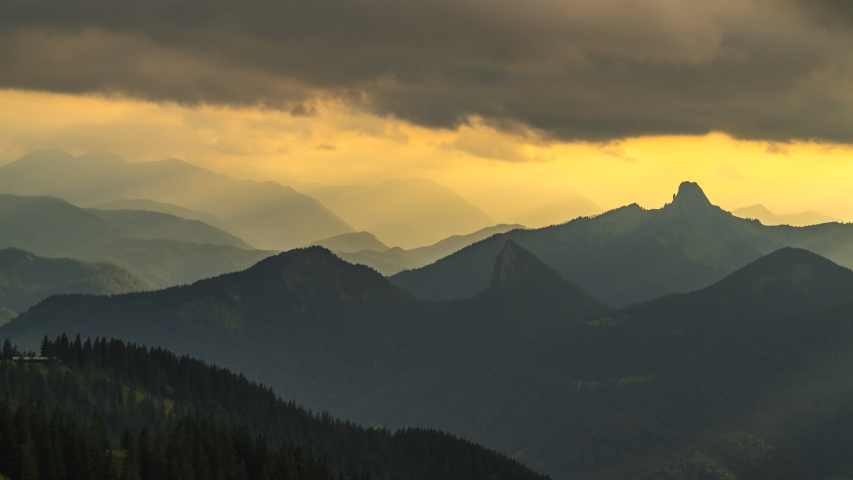 Timelapse of sun rays emerging though the dark storm clouds in the mountains at sunset bavaria germany alps mountains Royalty-Free Stock Footage #1057434358