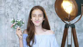 portrait. cute teenage girl with a small bouquet of flowers looking at the camera and smiling