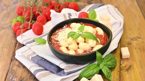 Homemade Italian Gnocchi with Red Sauce, Cheese with basil, olive oil . Close up. Home cooking. Traditional Italian cuisine from Rome and Sardinia. 