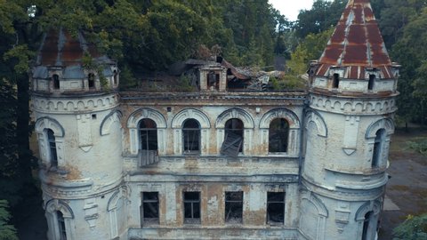 Abandoned 19th century palace or castle (manor or mansion house) with two towers and broken windows in Romanesque Revival architecture (or Neo-Romanesque) style. Aerial view.