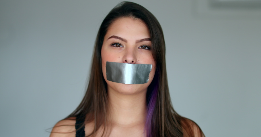 Assertive woman removing tape from mouth feeling relief and freedom to speak Royalty-Free Stock Footage #1057444258