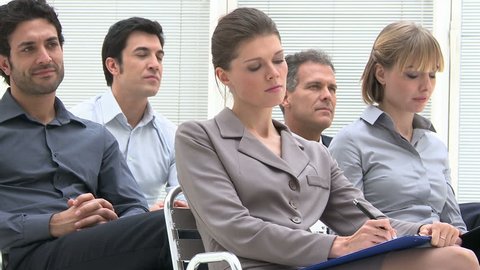 Business group of people attending an educational presentation. Businessmen and businesswomen are concentrated listening to the business conference. Businesspeople sitting at the business meeting.