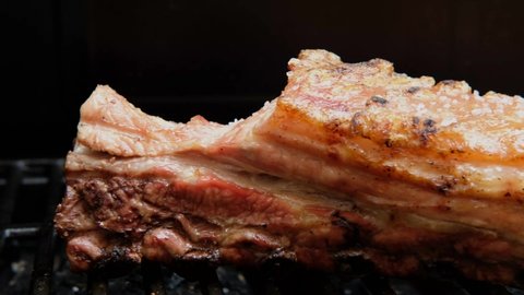 juicy smoked grilled pork belly meat on grill barbecue. close up shot. iron grill. pork ribs