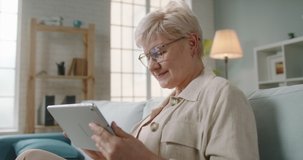 Mature caucasian lady in 50s is having video chat at home, using a tablet. Employer having a meeting with workers, tutor consulting students 4k footage