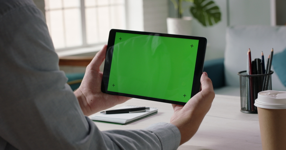 Close up shot of hands holding a tablet computer with green mock up screen. A template for video conference or online store 4k footage Royalty-Free Stock Footage #1057452676