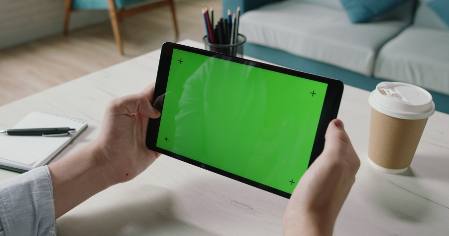 Freelance worker at home holding a tablet computer with green template screen, watching a webinar, studying online 4k template Royalty-Free Stock Footage #1057452745