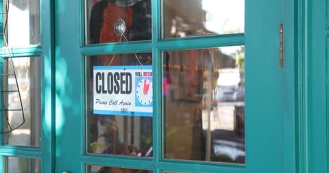 Store owner closing and opening business with open closed sign during covid 19 epidemic