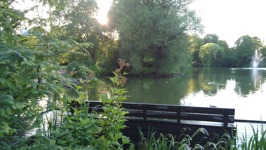 Pan over the pond in the public park Stadsparken in Lund, Sweden on a summer evening