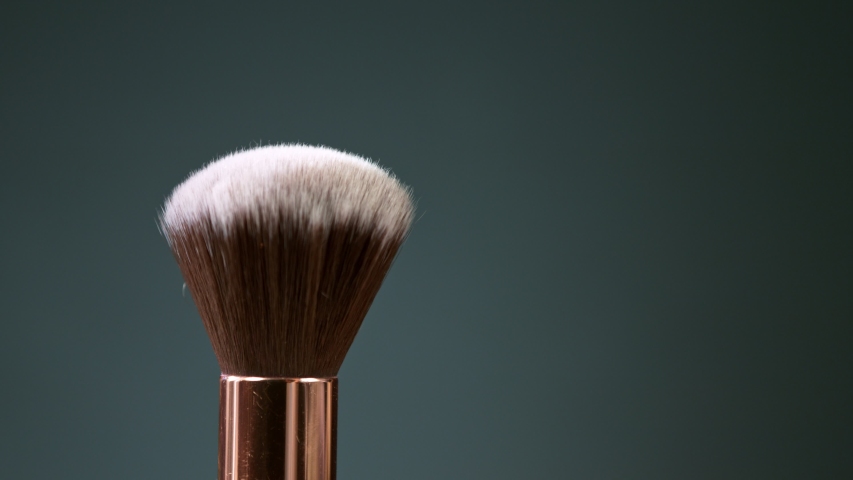 Makeup brushes touch each other on dark background and small particles of cosmetics, super slow motion, 1000 fps. | Shutterstock HD Video #1057466929