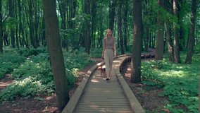 The girl walks with the dog on a leash, goes from right to left. 4k