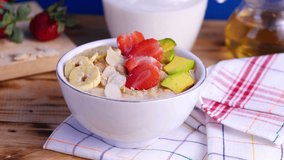 Oatmeal porridge with banana, strawberry and avocado. Healthy vegan breakfast