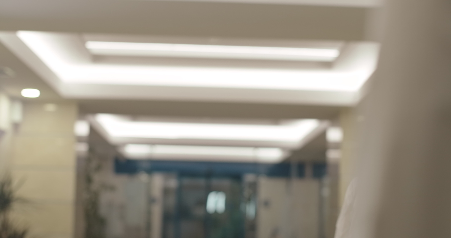 Confident mid-adult woman approaching reception in business center and smiling. Blond Caucasian businesswoman clarify meeting schedule in office. Cinema 4k ProRes HQ.