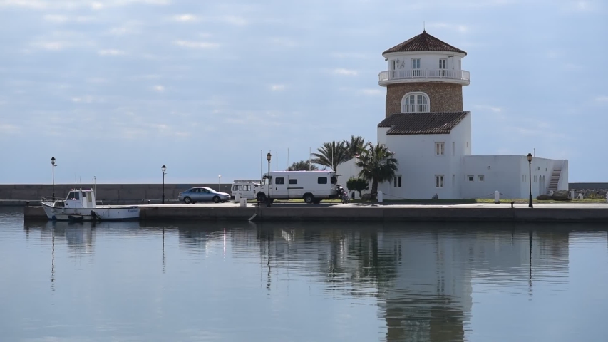 Lighthouse of Almerimar spanish resort town, waterside view to port tower against blue cloudy sky. Almeria, Andalusia. Spain