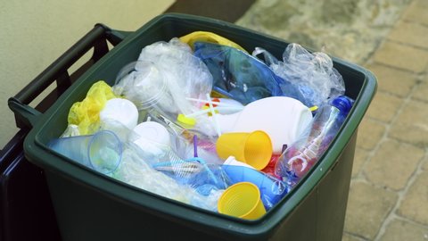 Wastebin full of plastic waste such as plastic bottles, cups, plastic bags and other plastic packaging ready for recycling	