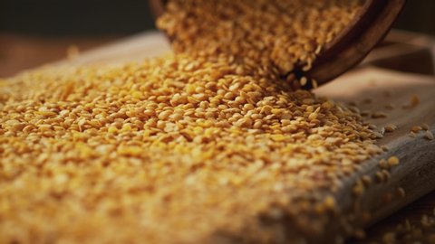 Yellow lentil grains on a delicious background and wood floor passes in front of the camera in slow motion. Macro, 4K, Phantom Camera,Very Close-up, 900 fps video.
