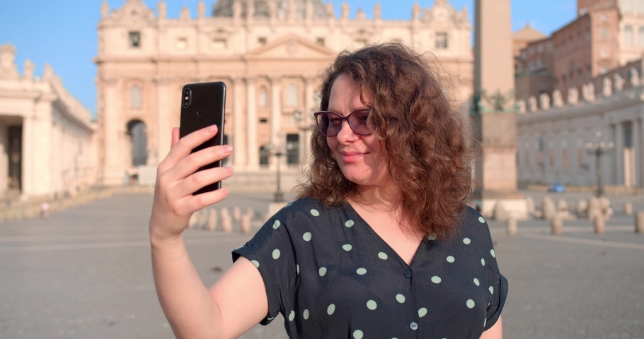 Adult Caucasian woman makes selfie in front of Vatican cathedral in Rome