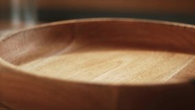In a beautiful light, dried apricots  fruit fall into the wooden plate in slow motion. 4K,Very close up, phantom camera,900 fps video.