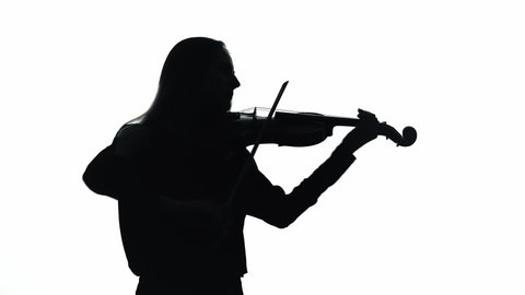 Young woman playing violin in white studio. Silhouette