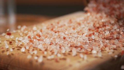 Pink himalayan rock salt on a delicious background and wood floor passes in front of the camera in slow motion. Macro, 4K, Phantom Camera,Very Close-up, 900 fps video.