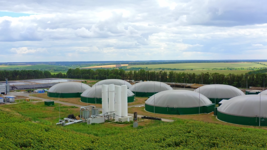 Organic biofuel plant on green field. Modern biogas plant among nature in summer. Biomass production. Innovative storage tanks for biogas. Royalty-Free Stock Footage #1057492225
