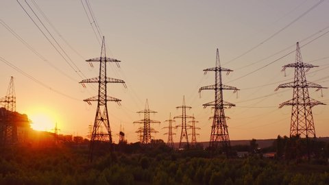 High voltage electric towers at sunset. Transmission power line. Parts of electrical equipment and high voltage power line insulators in the evening.