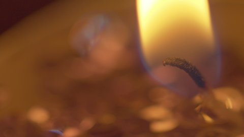 Macro view of the golden flame of a candle lighting the darkness - static isolated