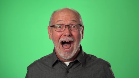 Man shocked, saying WOW. Handsome guy with bald gray hair surprised to camera on green screen background.