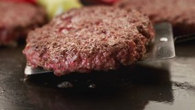Cooking beef patties for burgers. Slow motion. Hamburger patties are turned over on the grill. Phantom camera, 4k.
