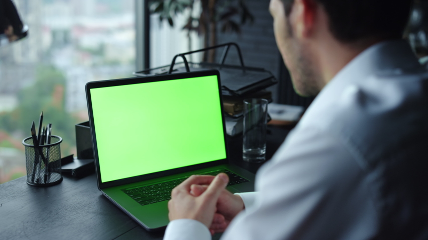 Back view business man having video call on laptop green screen at remote workplace. Male professional talking during video conference on laptop computer with chroma key in office. Royalty-Free Stock Footage #1057501390