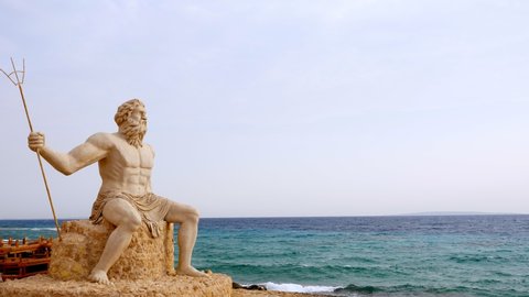 monumental statue of God Poseidon on the beach, against the backdrop of the sea.