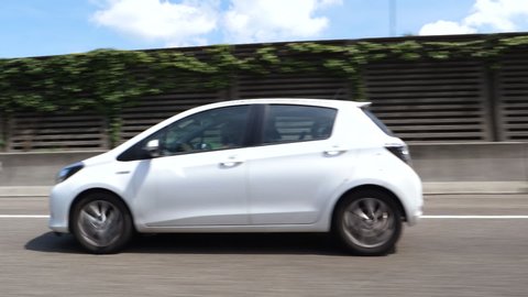 Germany - Circa 2019: Slow motion footage defocused view of white mini Toyota car driving fast on the German autobahn