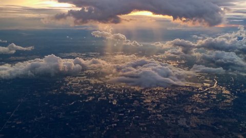Amazing golden fluffy clouds moving softly on the sky and the sun shining through the clouds with beautiful rays. Sunset ,Sunrise with many white clouds many shapes, aerial view landscape of city.