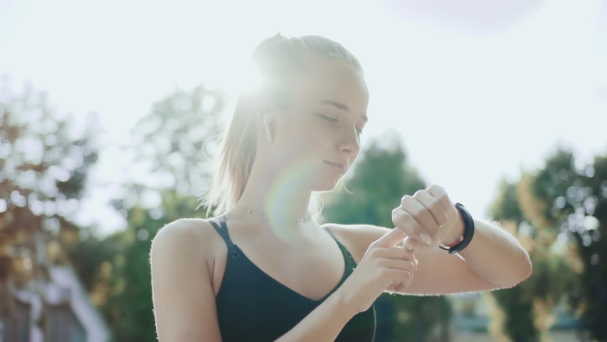 Close up young fitness woman look at smart watch at sunlight outdoors athlete workout equipment app technology monitor active gadget jogger tech slow motion | Shutterstock HD Video #1057514593