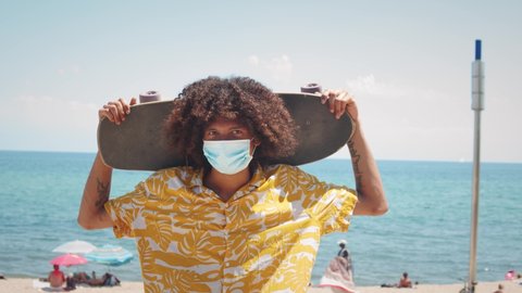 Black latin american man with afro haircut in medical mask during coronavirus lockdown, pandemic, happy young hispanic teenager post covid portrait, student in protection safety mask
