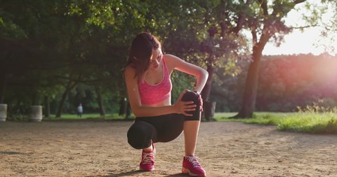 sport woman injury her knee while running in th park