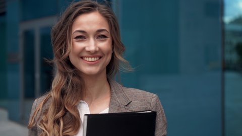 Businesswoman successful woman business person standing outdoor corporate building exterior Excited elegance cute caucasian confidence professional business woman holding folder documents Slow motion